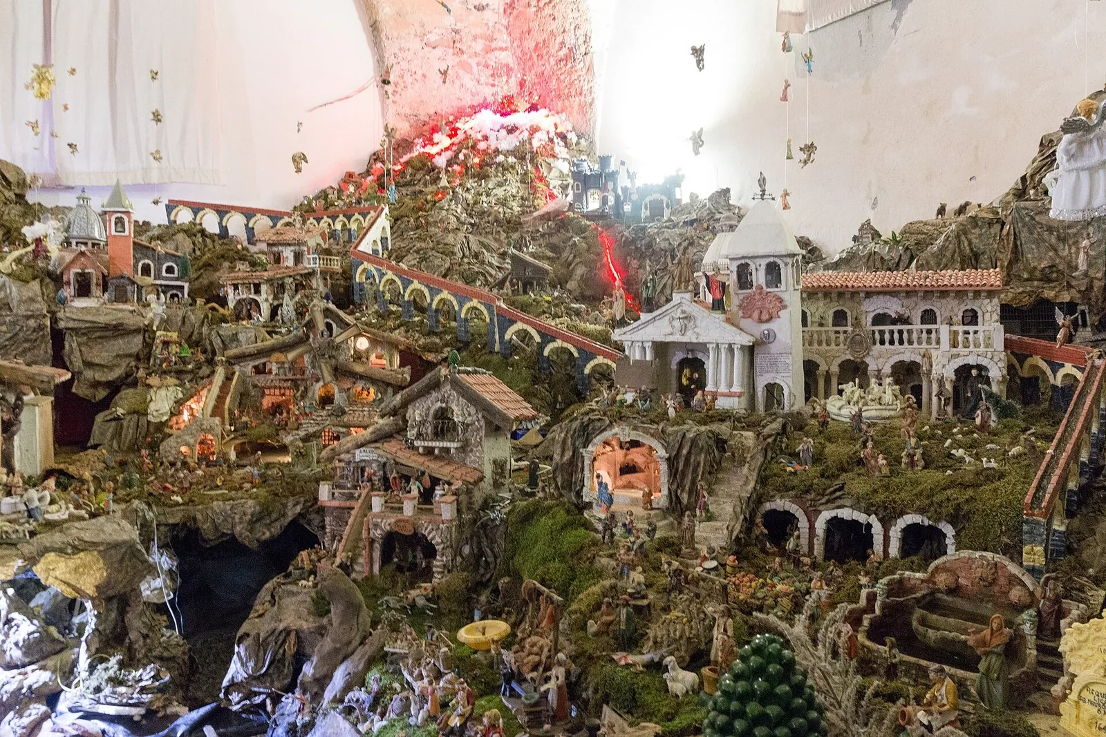 Scena di presepe vivente con figuranti in costume in un vicolo illuminato